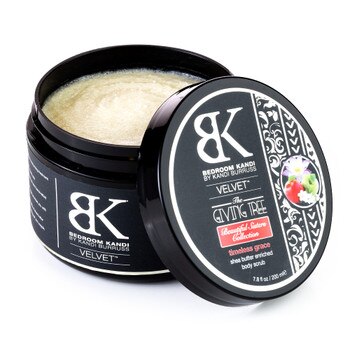 An image of an open jar of Velvet shea body scrub with the pale gold exfoliating scrub visible inside the jar and the lid to the side. It is in the timeless grace fragrance.